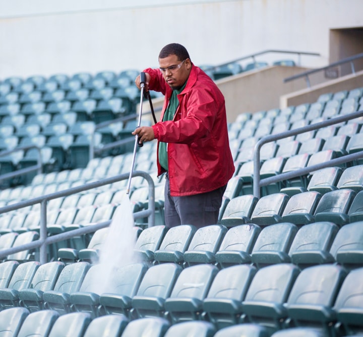 Man cleaning stadium seats