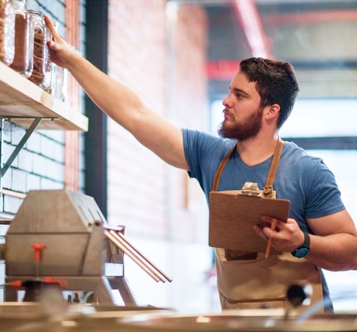A worker in an apron doing inventory.