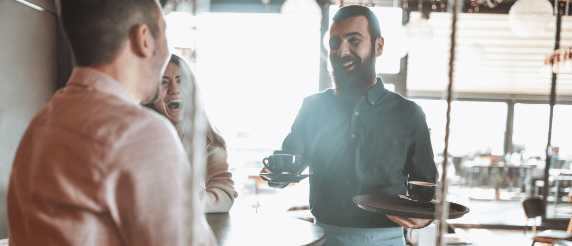 Person serving coffee and smiling