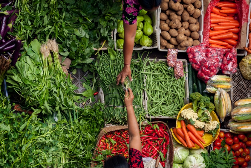 A large stand at the farmer's market offering a wide variety of vegetables.