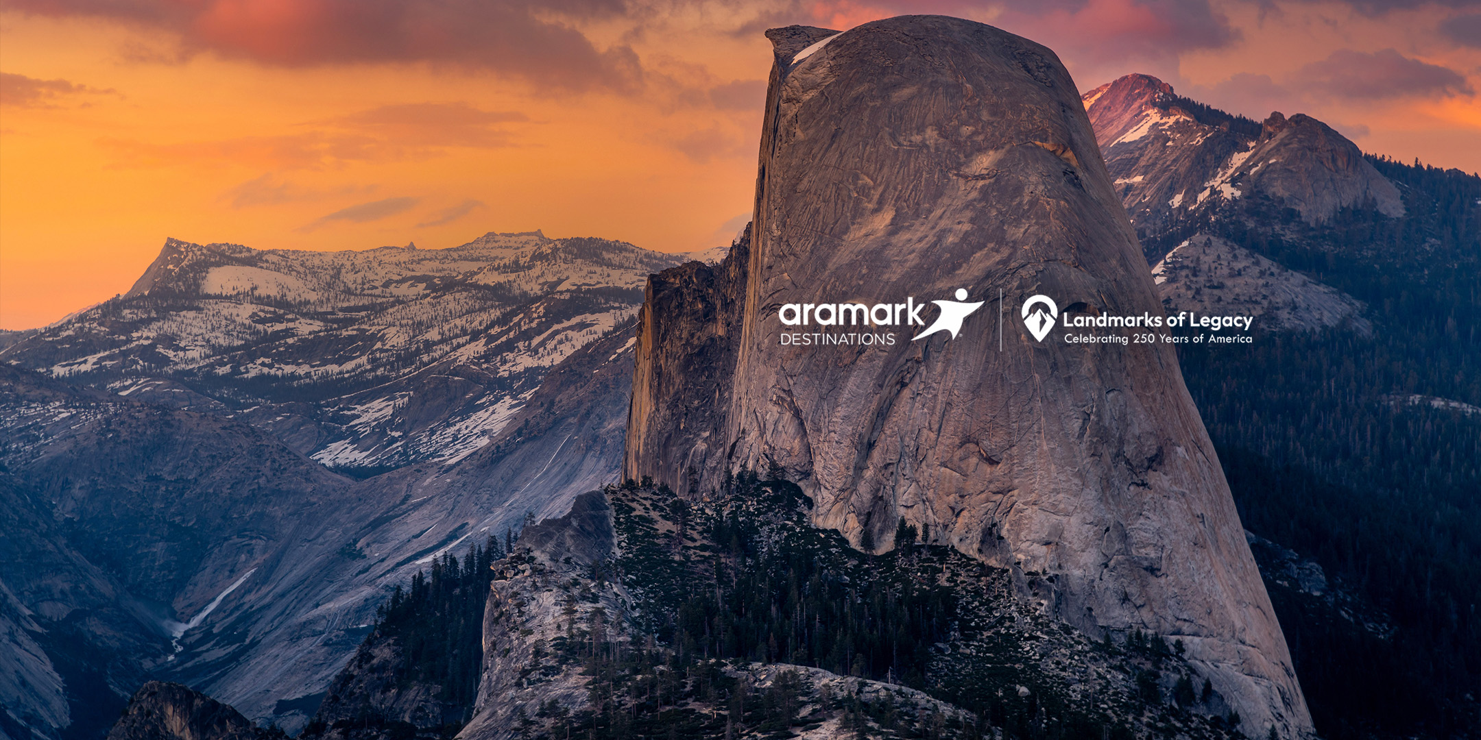 Rock formations and mountains against a sunset.