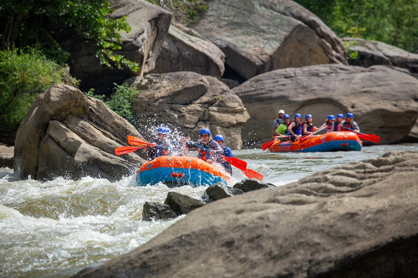 River rafters paddling through rapids.